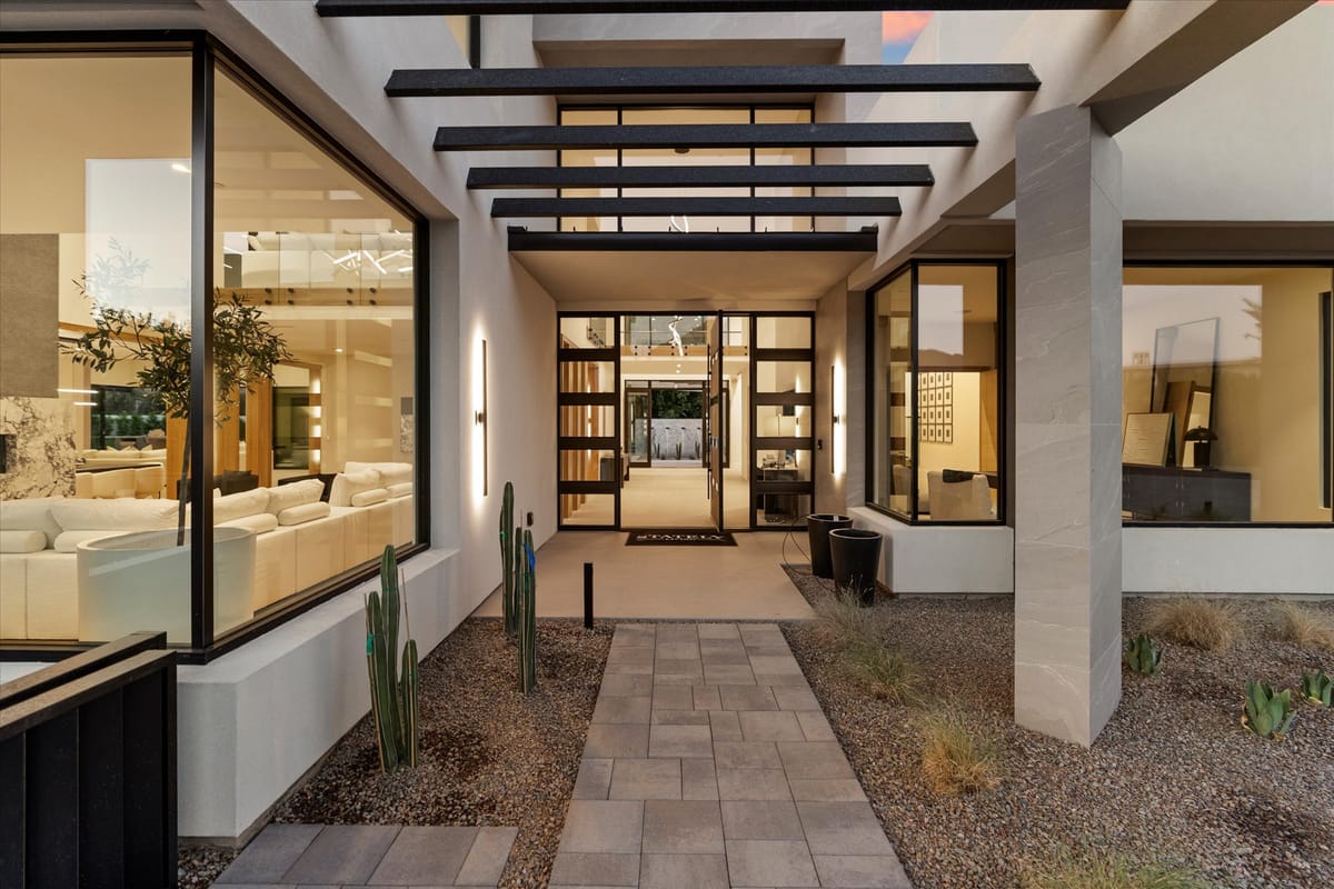 Covered entry walkway with pergola shadows and desert planting