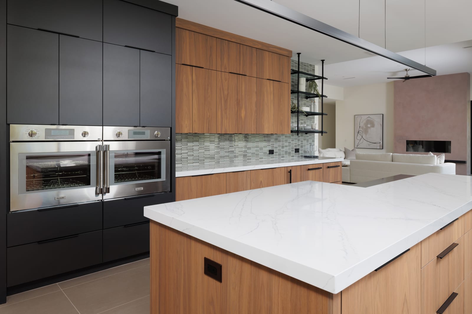Kitchen with black and natural wood cabinetry and marble island
