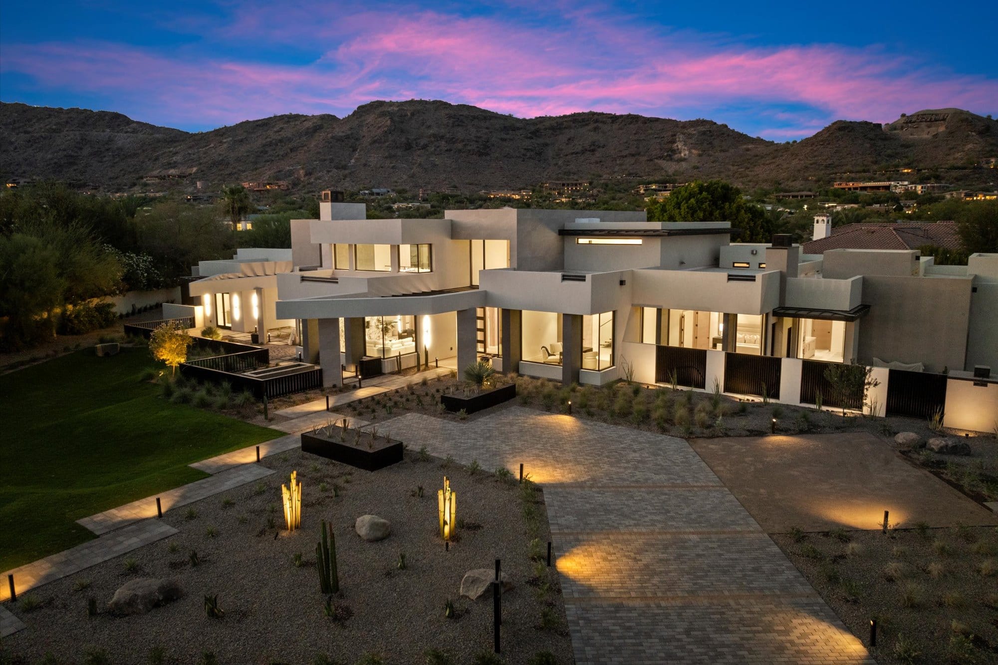 Custom desert modern home at dusk with mountain views, built by Arcadia Building Co